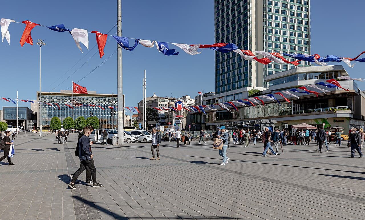 Taksim Square with flag garlands, the metro entrance and Ataturk Cultural Center in the background